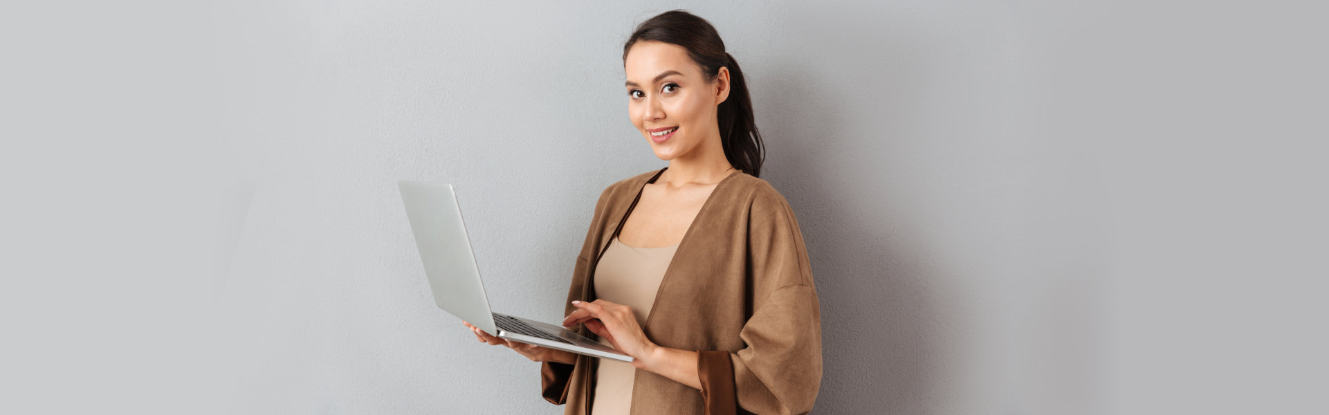 woman standing holding a laptop